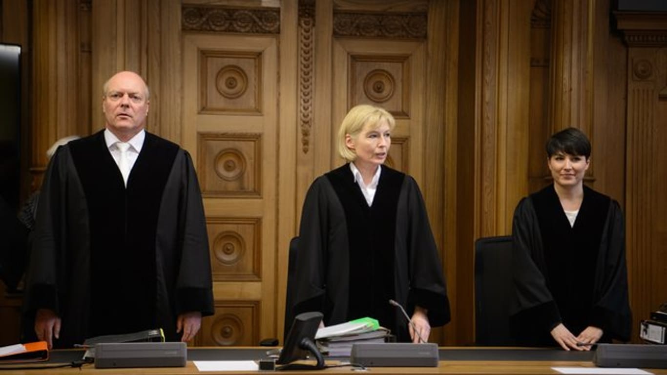 Die Vorsitzende Richterin Mechthild Weinland (M) und ihre Beisitzer stehen im Gerichtssaal in Tübingen.