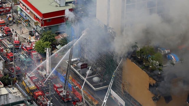 Feuerwehrleute kämpfen vor dem "Waterfront Manila Pavilion" gegen die Flammen. Feuerwehrleute kämpfen vor dem "Waterfront Manila Pavilion" gegen die Flammen.