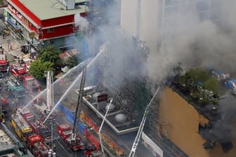 Feuerwehrleute kämpfen vor dem "Waterfront Manila Pavilion" gegen die Flammen.