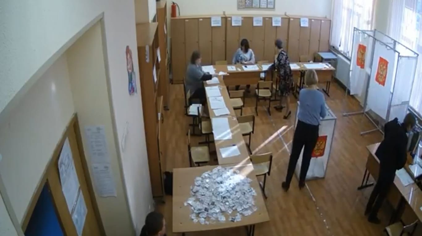 Beim Mogeln erwischt: In einem Wahllokal in Ljuberzy steckt eine Mitarbeiterin bündelweise Stimmzettel in die Urne.