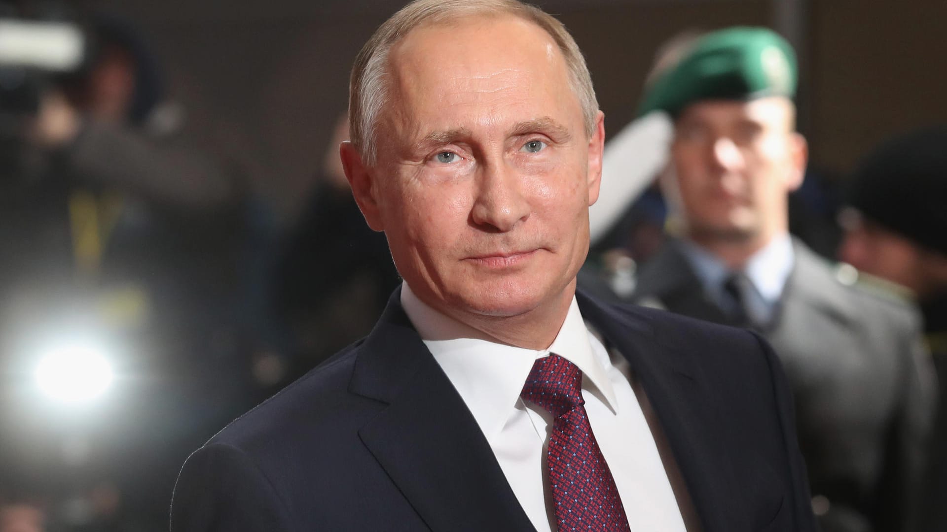 Der bestätigte russische Präsident Wladimir Putin mit einem Soldaten im Hintergrund: Kreml-Chef kündigt Kürzung der Militärausgaben an. Der bestätigte russische Präsident Wladimir Putin mit einem Soldaten im Hintergrund: Kreml-Chef kündigt Kürzung der Militärausgaben an.