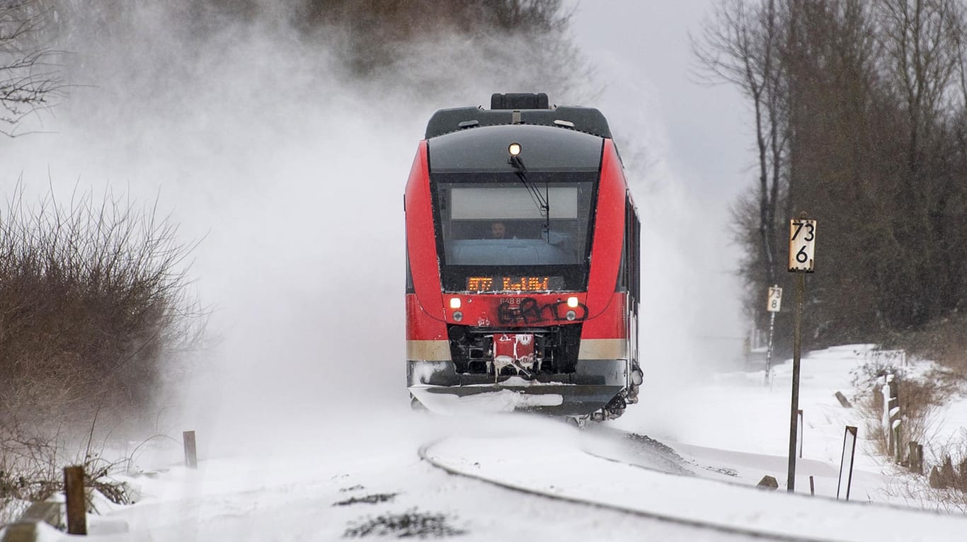 Eine Regionalbahn fährt über zugeschneite Gleise: Drei Mädchen wurden beim Selfies machen fast vom Zug überrollt.