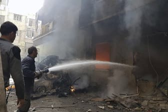 Kein Ende des Kriegs in Syrien: Nach einem Luftangriff versuchen Männer einen Brand zu löschem.