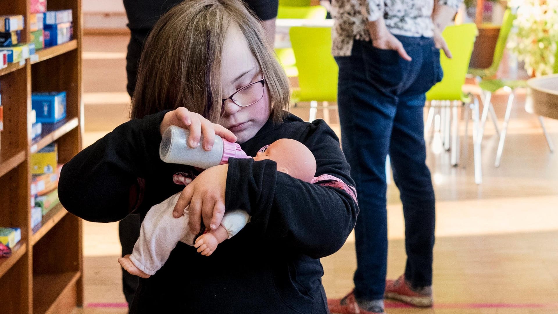 Nora hat das Down-Syndrom und spielt im Eltern-Kind-Treff mit einer Puppe.