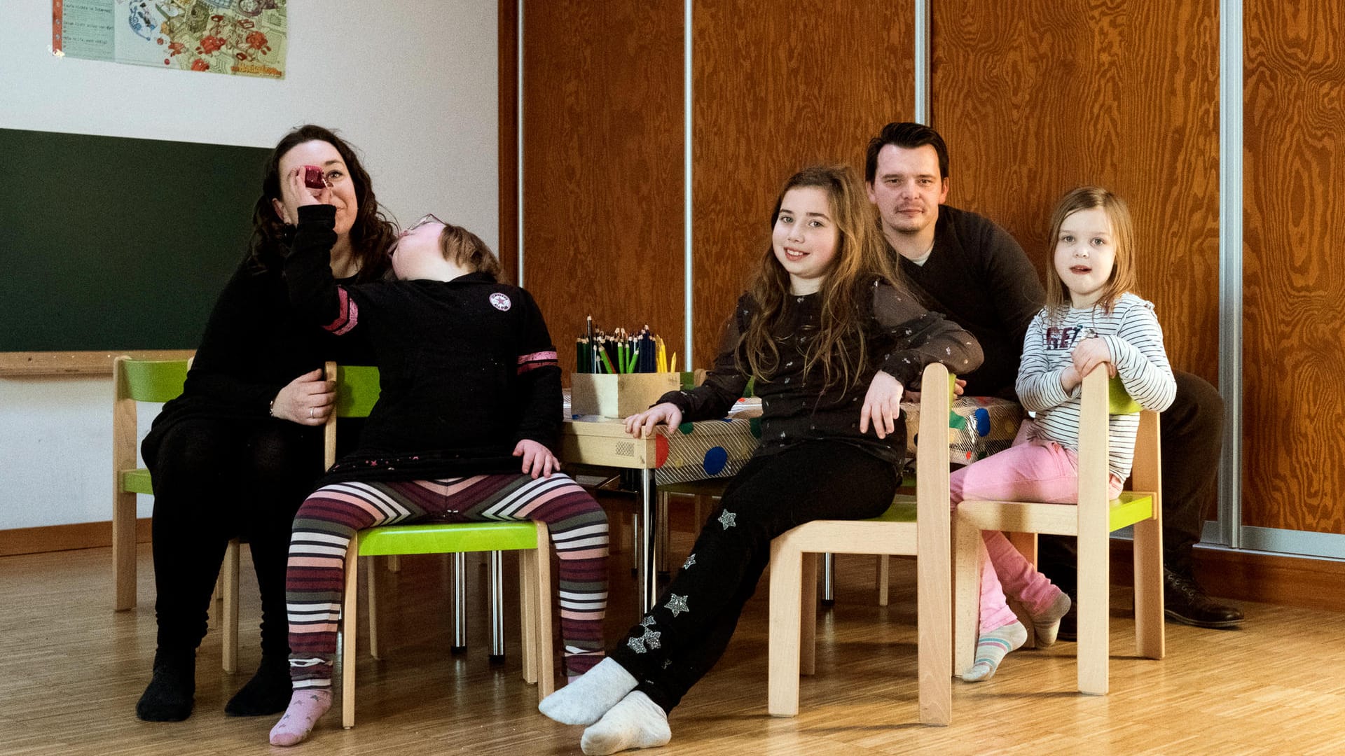 Familie Blum: Nora spielt bei einem Familienfoto mit einem Schoko-Muffin, während ihre Geschwister Lucy (r) und Emma (M) und die Eltern Mareike und Dennis Blume für die Fotografin posieren.