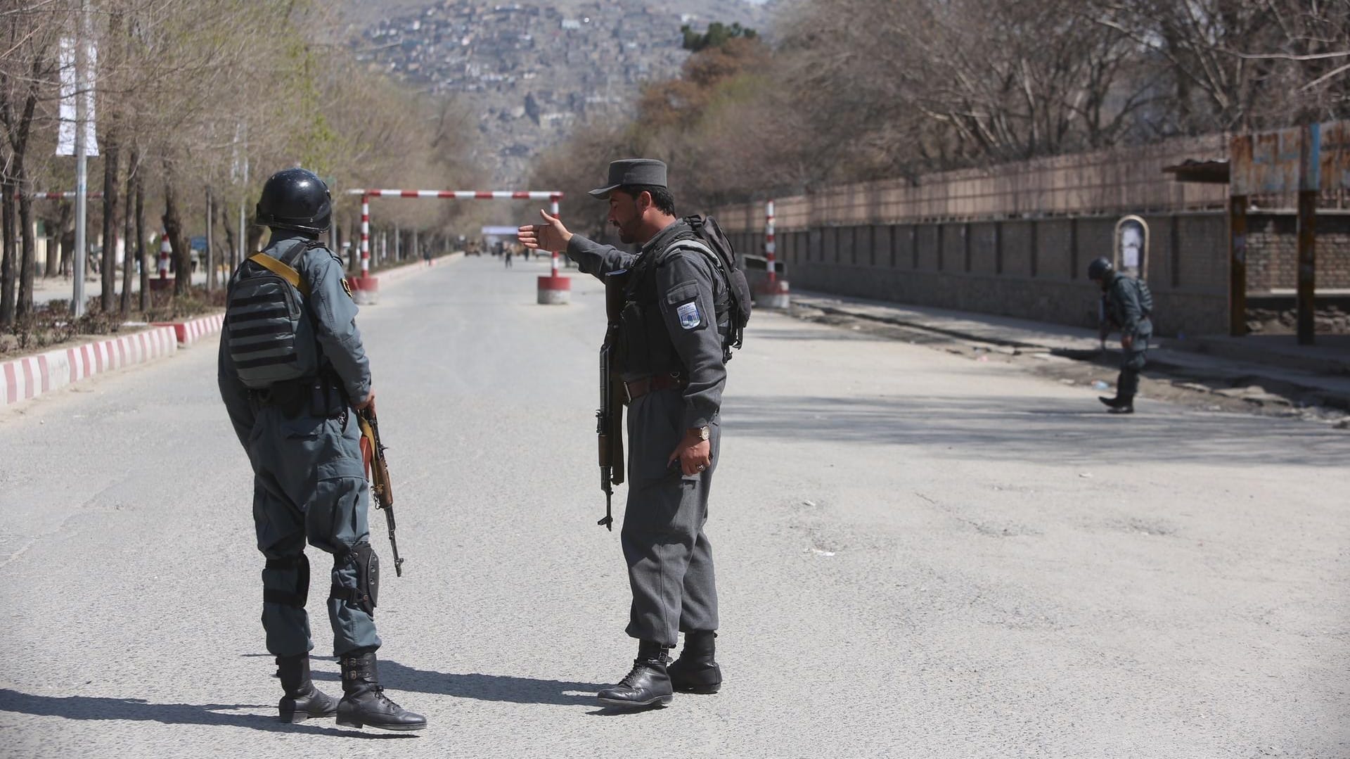 Polizei sichert eine Straße in der Nähe des Anschlagsorts in Kabul: Mindestens 26 Menschen sollen bei dem Selbstmordanschlag ums Leben gekommen sein. Polizei sichert eine Straße in der Nähe des Anschlagsorts in Kabul: Mindestens 26 Menschen sollen bei dem Selbstmordanschlag ums Leben gekommen sein.