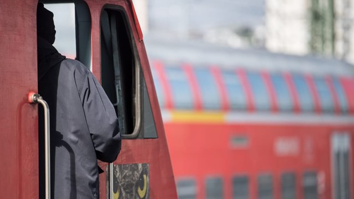 Ein Lokführer steht im Hauptbahnhof von Stuttgart an der Tür zu einem Führerstand.