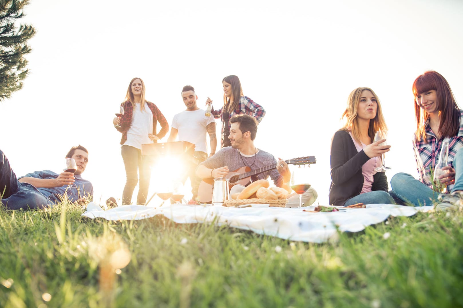 Eine Gruppe von Freunden picknickt: Forscher fanden heraus, dass Erwachsene durch die Sommerzeit im Schnitt eine halbe Stunde länger draußen ihre Freizeit genießen