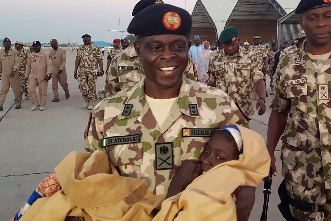 Ein nigerianischer Soldat trägt ein freigelassenes Mädchen: Die Ex-Geiseln wurden in die Hauptstadt Nigerias, Abuja, gebracht.