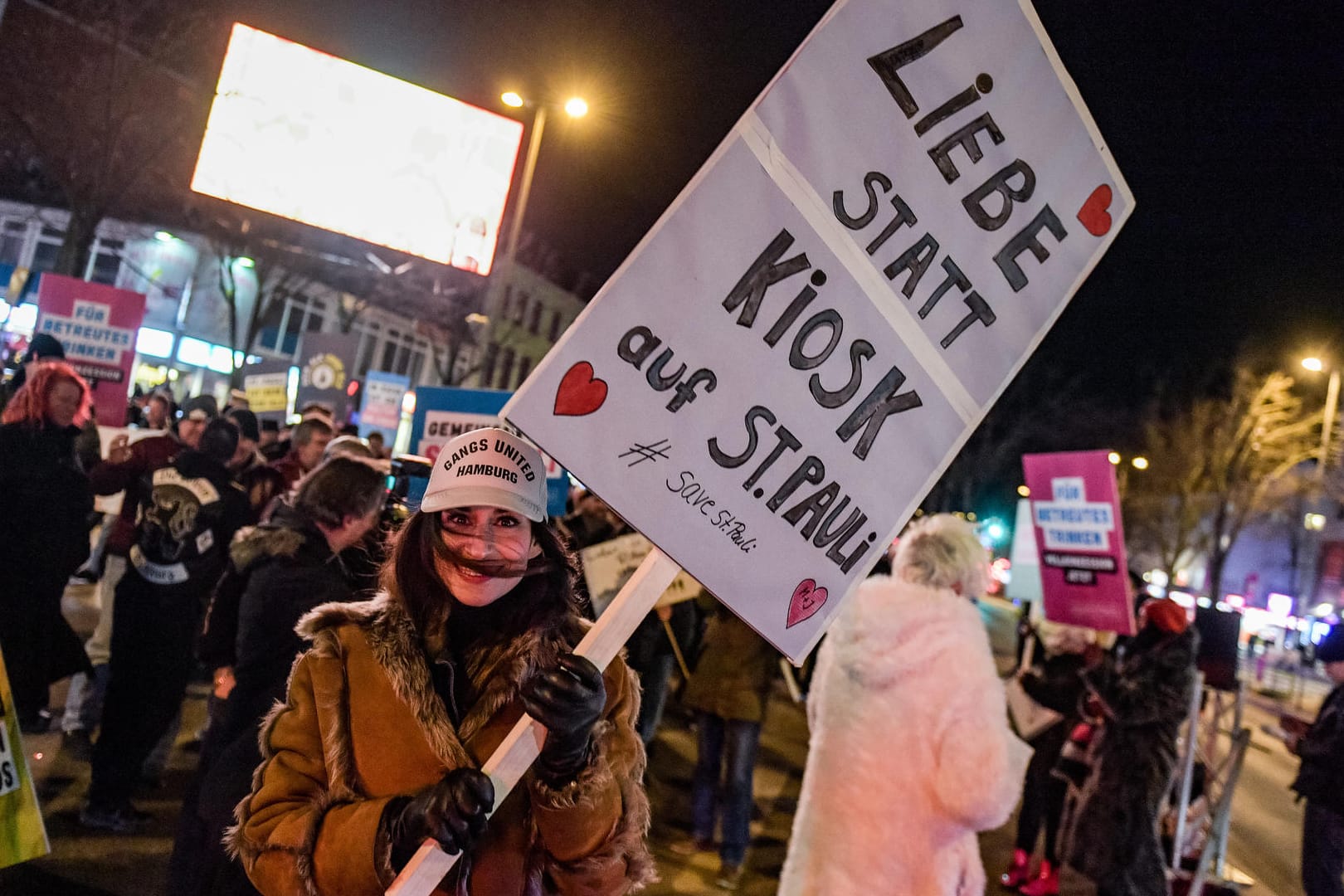 Teilnehmerin der Demonstration "Save St. Pauli" trägt ein Schild mit der Aufschrift "Liebe statt Kiosk auf St. Pauli" in den Händen: Billig-Alkohol sorgt auf St. Pauli erneut für Protest.
