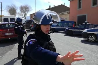 Polizisten sichern während einer Geiselnahme in einem Ort am Rande von Carcassonne eine Straße.