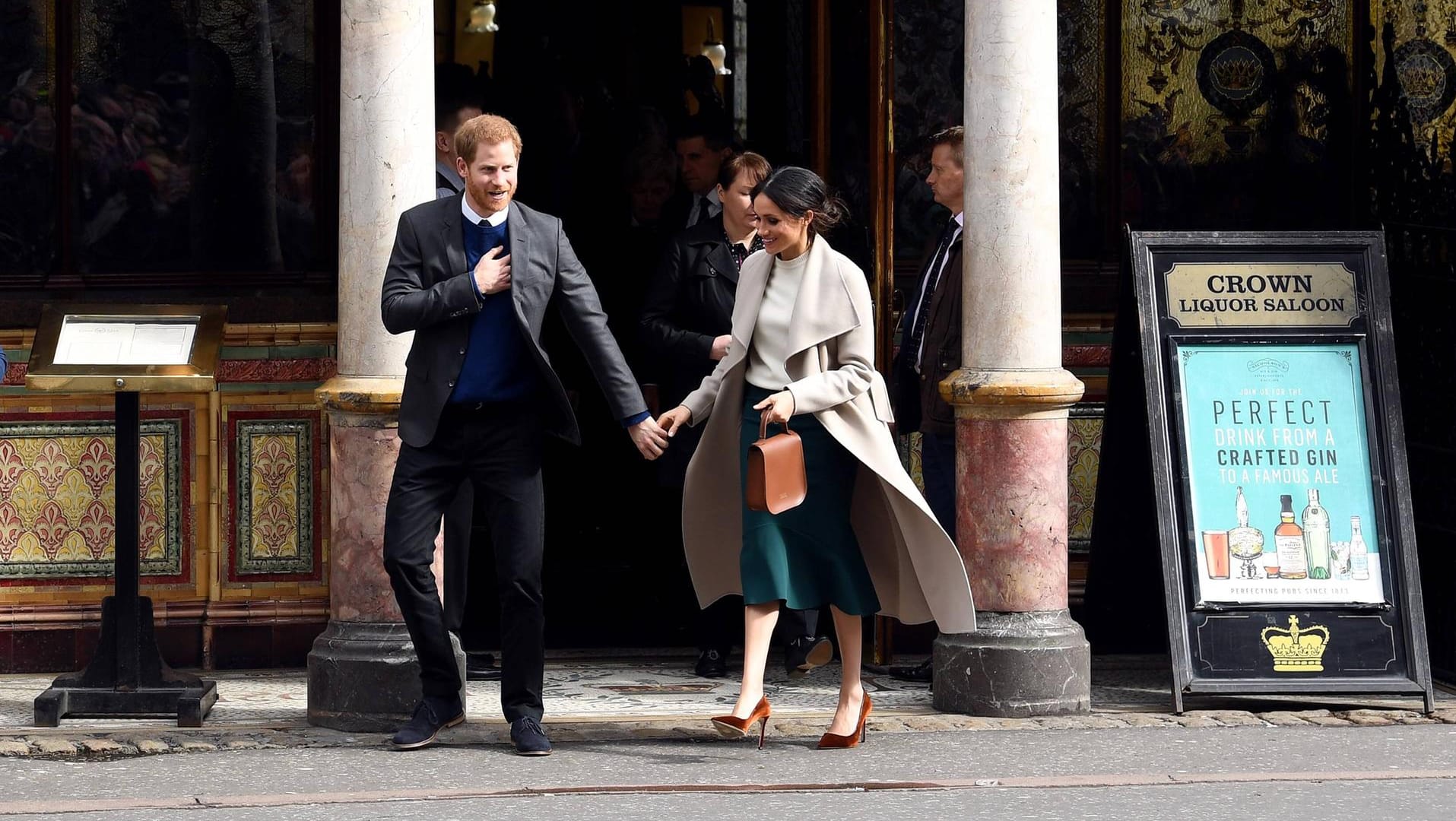 Stilsicher unterwegs: An Harrys Seite kombinierte Meghan dunkelbraune Pumps zum beigen Mantel.