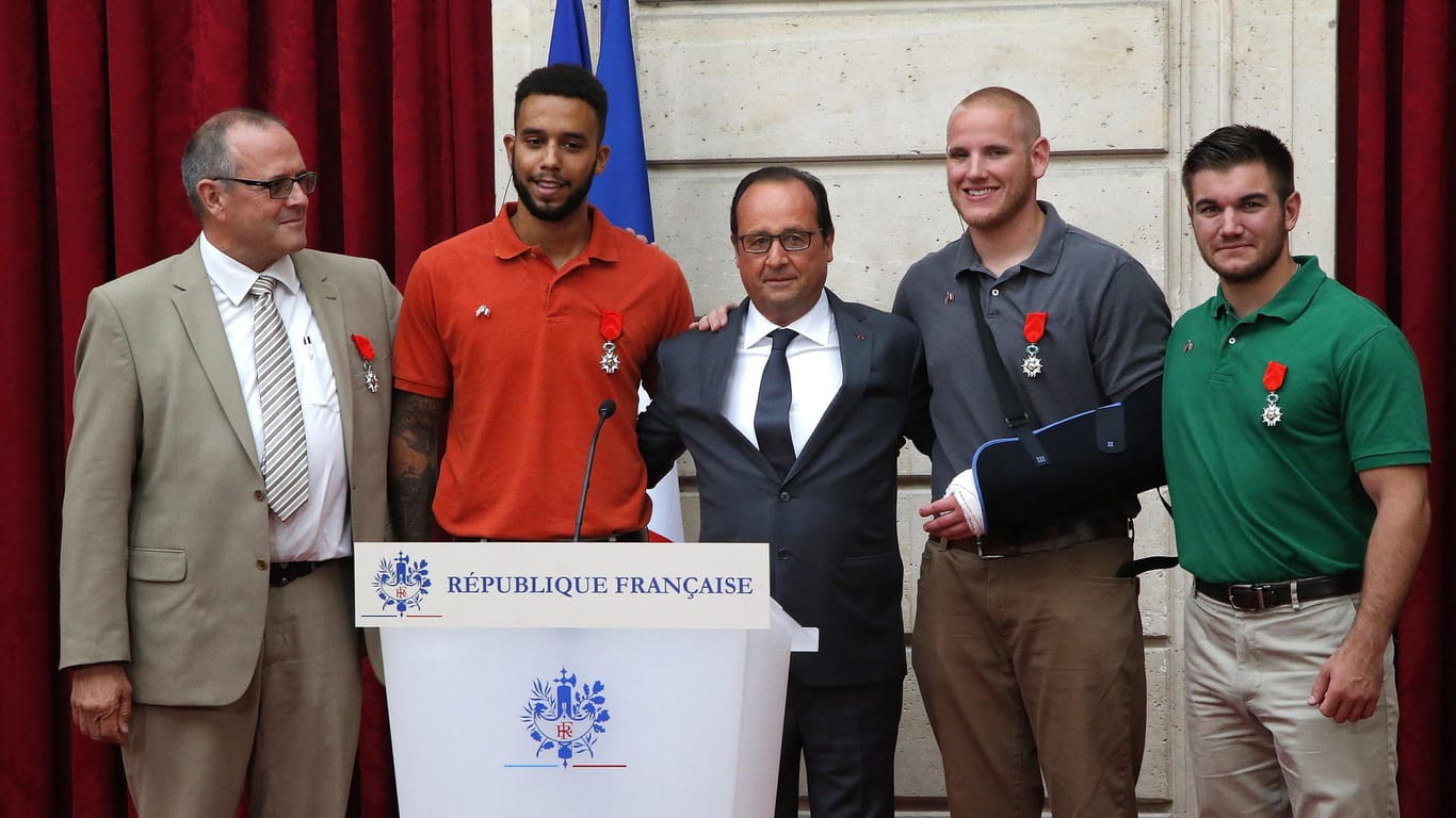 Frankeichs Präsident Francois Hollande mit den Männern, die in einem Schnellzug einen Attentäter überwältigt haben: Sie erhielten einen Orden für ihr Einschreiten.