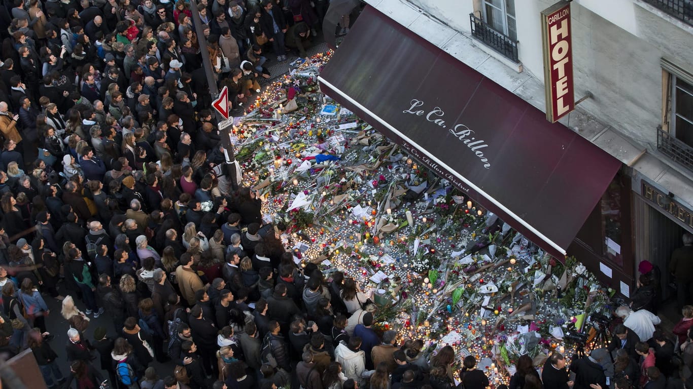Menschen legen am 15.11.2016 vor dem Restaurant Carillon in Paris Blumen nieder: Ein Jahr zuvor schossen Terroristen auf das Restaurant und töteten Dutzende Menschen.