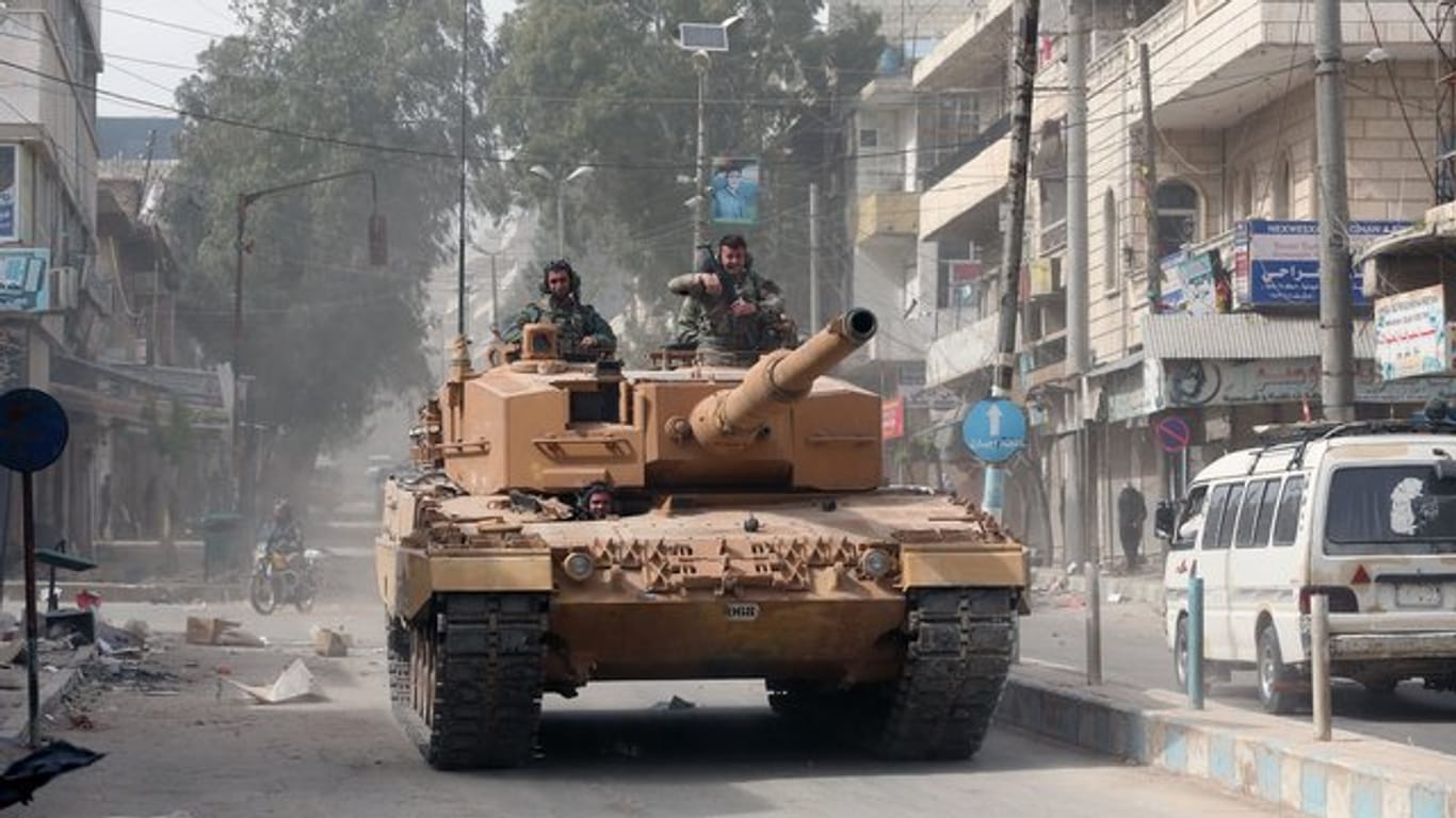 Ein türkischer Panzer fährt durch eine Straße in Afrin.