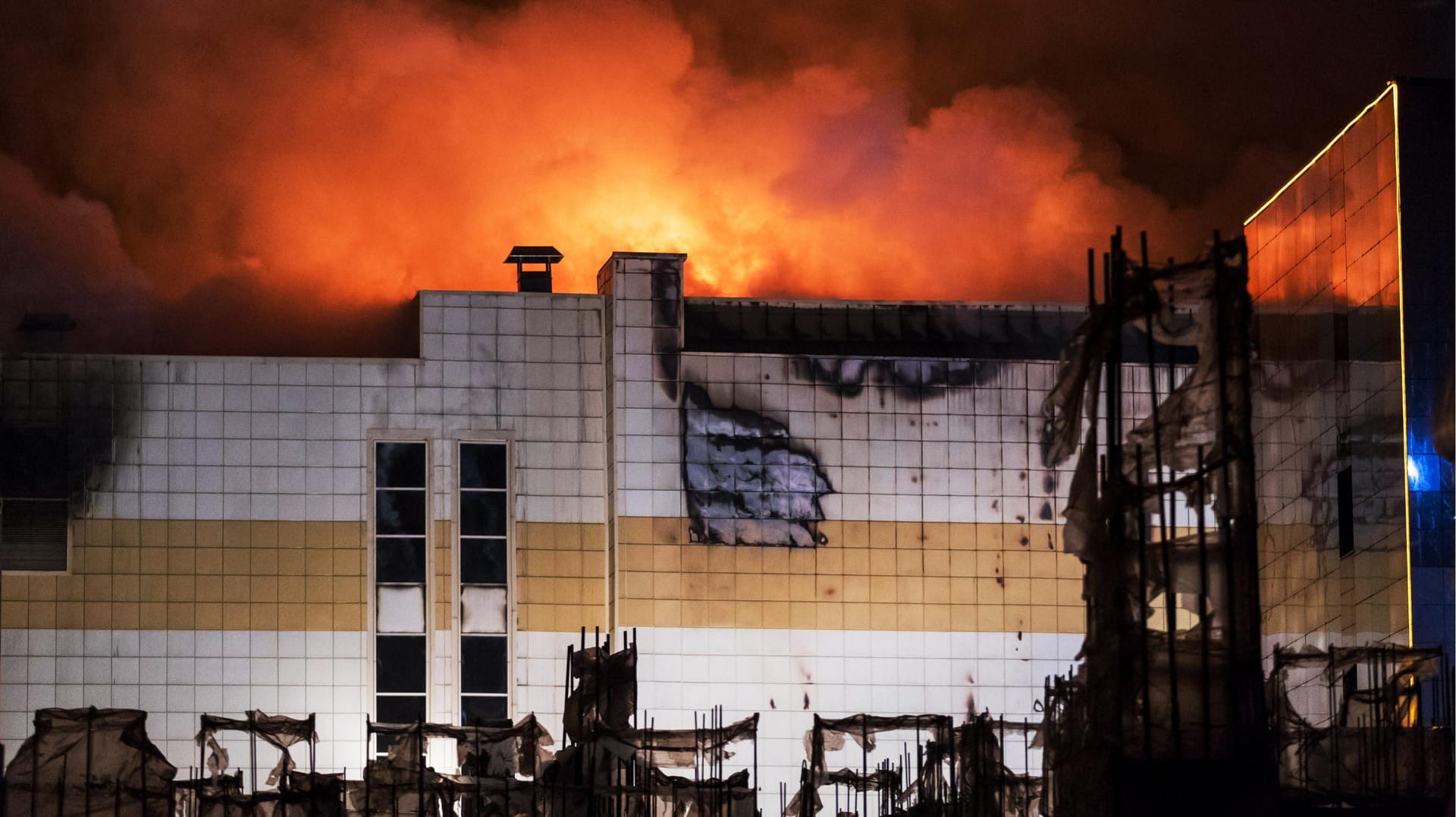 Flammen sind bei einem Brand eines Einkaufszentrums zu sehen.