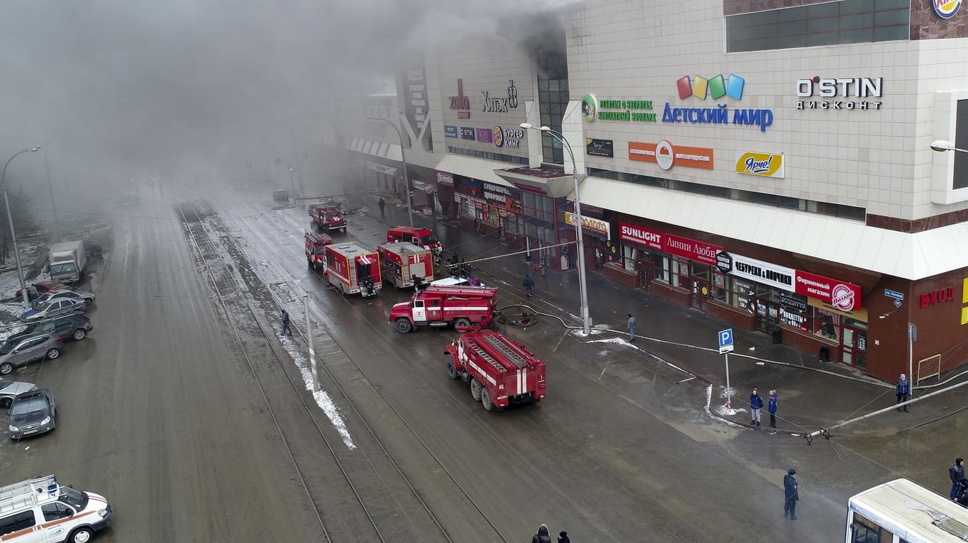 Rauch und Feuerwehrfahrzeuge vor dem Einkaufszentrum.