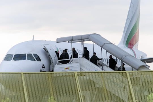 Abgelehnte Asylbewerber steigen auf dem Baden-Airport in Rheinmünster in ein Flugzeug.