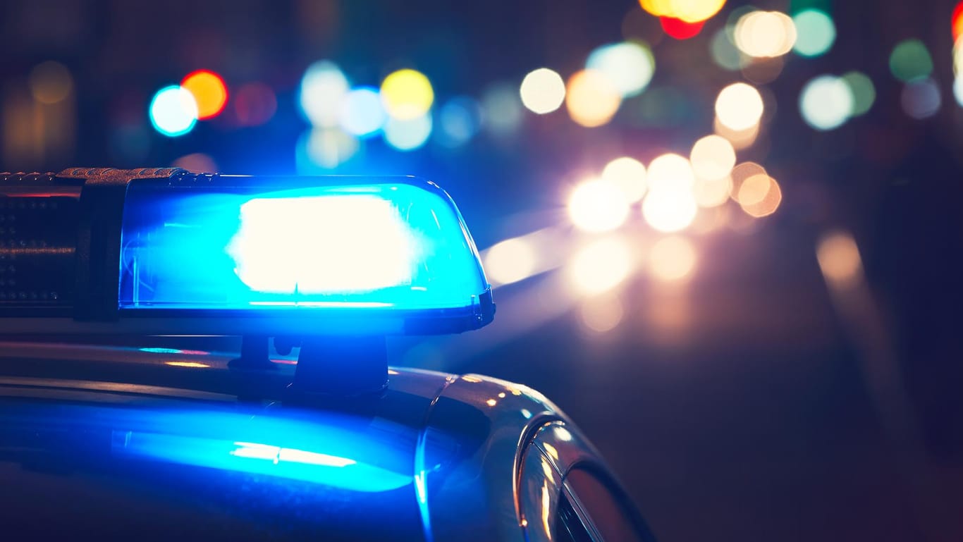 Polizeiauto mit Blaulicht nachts auf einer Straße: Die Polizisten fanden den 16-Jährigen auf dem Boden liegend mit einer Wodkaflasche.
