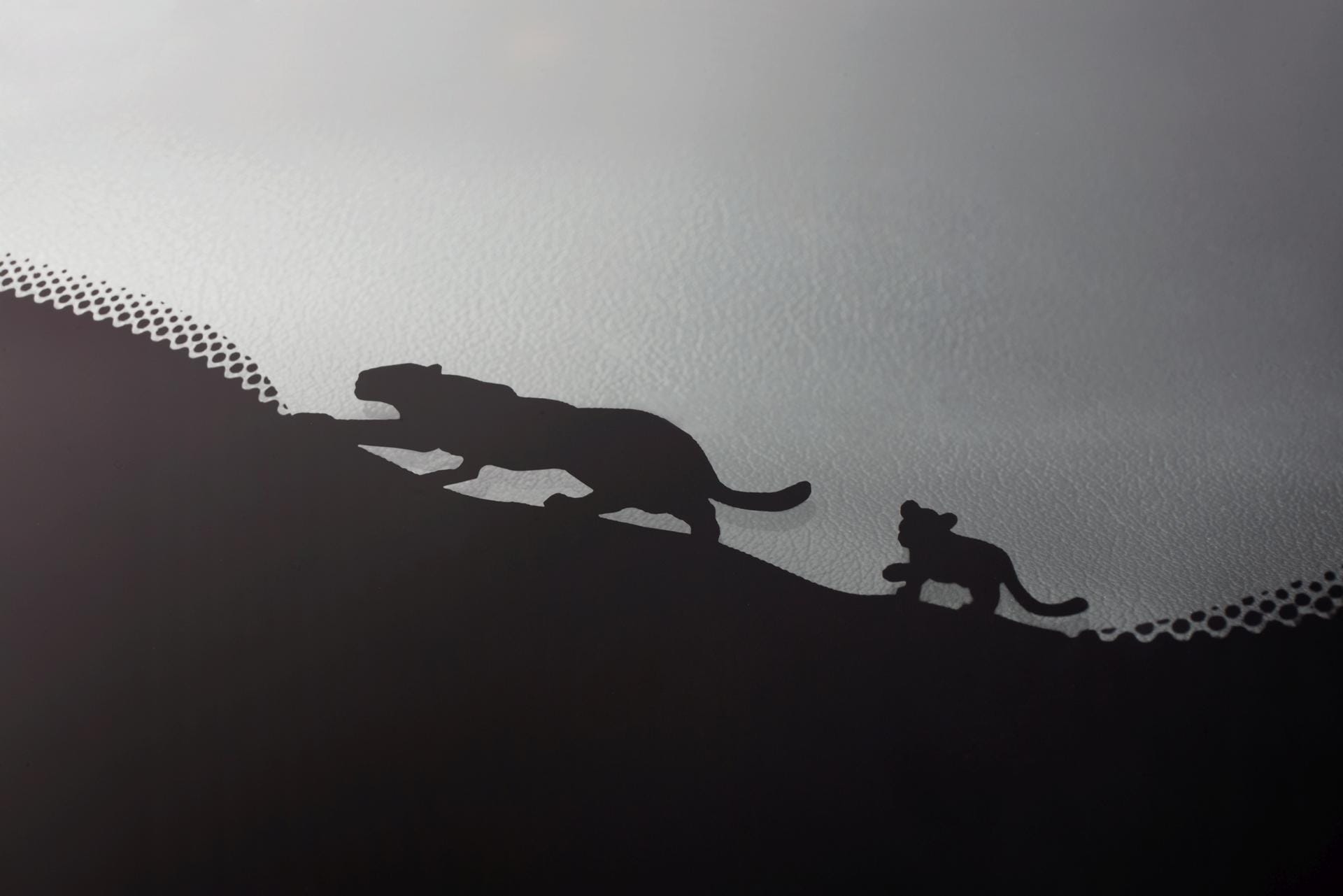 Frontscheibe des Jaguar E-Pace: In der schwarzen Umrandung pirschen eine Jaguar-Mama und ihr Junges.