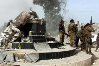 Soldaten der Freien Syrischen Armee feiern um eine Statue der kurdischen Kultur: Deutscher wegen Terrorverdachts an türkisch-syrischer Grenze gefasst.