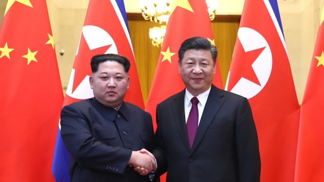 Nordkoreas Machthaber Kim Jong Un (l) und Chinas Präsident Xi Jinping geben sich die Hand in Peking.