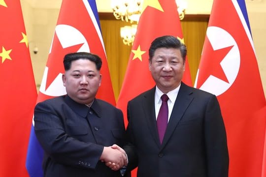 Nordkoreas Machthaber Kim Jong Un (l) und Chinas Präsident Xi Jinping geben sich die Hand in Peking.