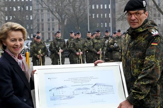 Zusammen mit Oberst Dirk Waldau, Kommandeur der Schule für Feldjäger und Stabsdienst der Bundeswehr, hält Verteidigungsministerin Ursula von der Leyen eine Urkunde zur Umbenennung der Emmich-Cambrai-Kaserne in der Händen.