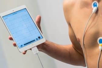 Ein Mann demonstriert ein mobiles 22-Kanal-EKG-System für Tablet-PC und Smartphone: Mehr Digitalisierung bedeutet auch mehr Angriffsmöglichkeiten für Hacker: Was bedeutet das für Medizintechnik und Gesundheitsdaten?