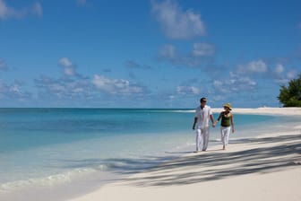 Ein Paar am Strand: Reiseveranstalter locken Urlauber jetzt mit neuen Zahlungsmöglichkeiten.