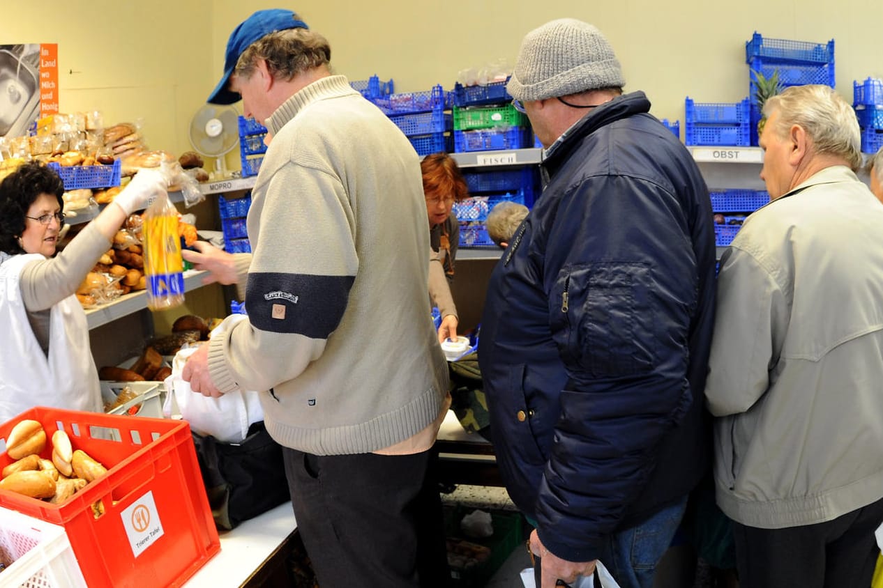 Bedürftige stehen bei der Trierer Tafel für Lebensmittel an: Hartz IV wird wohl auf absehbare Zeit als Grundsicherung bleiben.