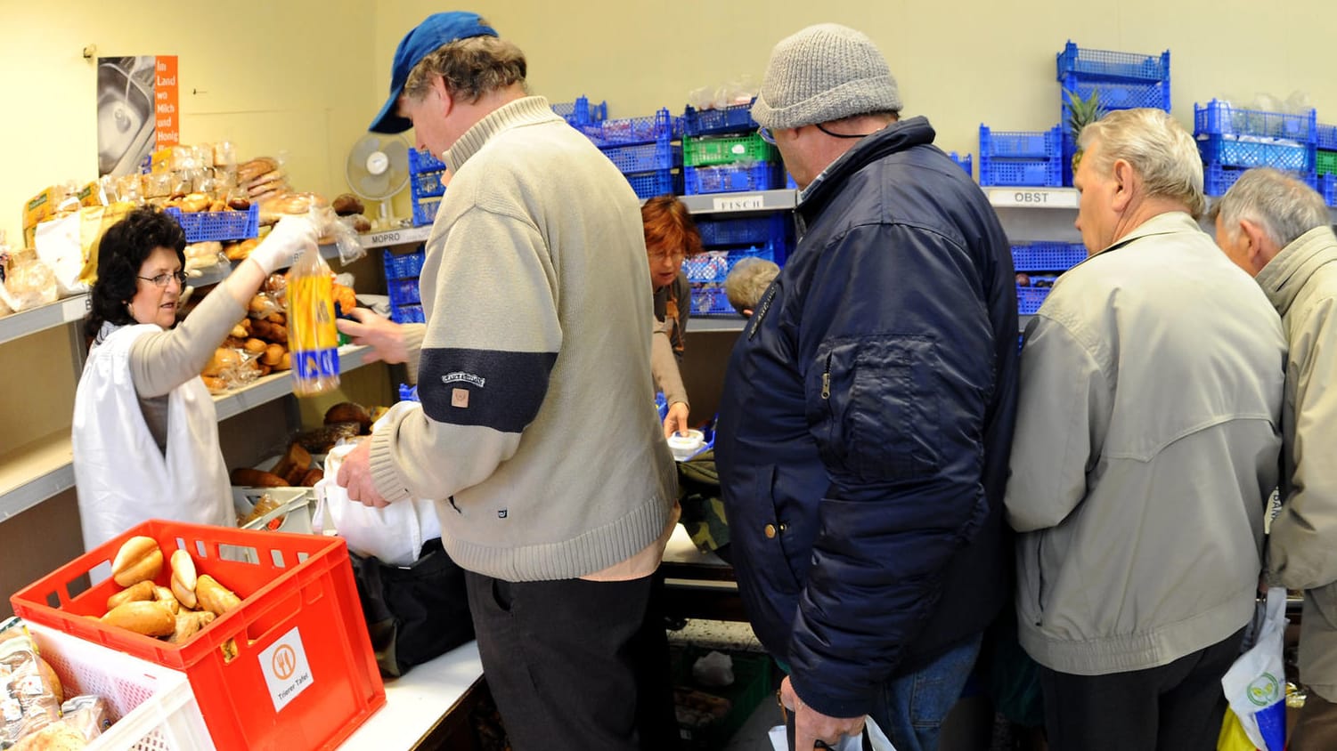 Bedürftige stehen bei der Trierer Tafel für Lebensmittel an: Hartz IV wird wohl auf absehbare Zeit als Grundsicherung bleiben.