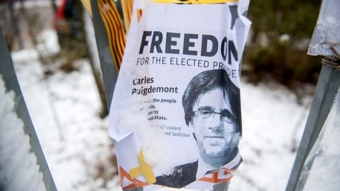 Ein Flugblatt mit dem Bild des ehemalige Regionalpräsidenten Kataloniens, Carles Puigdemont, hängt am Zaun der JVA Neumünster.
