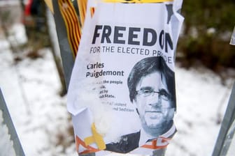 Ein Flugblatt mit dem Bild des ehemalige Regionalpräsidenten Kataloniens, Carles Puigdemont, hängt am Zaun der JVA Neumünster.