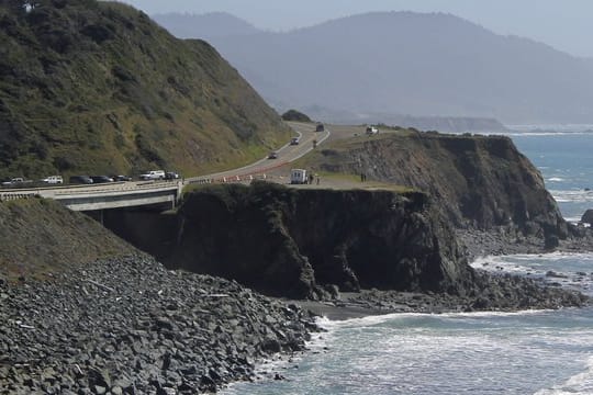 Einsatzkräfte untersuchen die Stelle am Highway 1, an der beim Sturz über eine Klippe mindestens fünf Familienmitglieder in ihrem Auto ums Leben gekommen sind.
