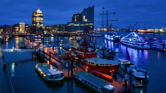 Boote liegen unter einer verhangenen Wolkendecke im Hamburger Hafen.