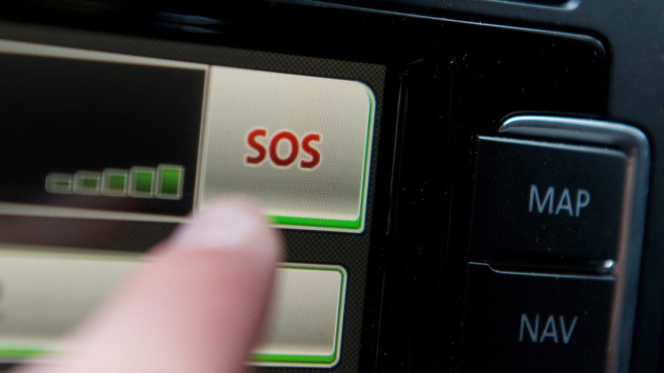 Schriftzug "SOS" ist auf dem Display eines Bordcomputers mit Touchpad eines Volkswagen Fahrzeuges: Kommt es zum Unfall, erkennen Beschleunigungssensoren im Stecker die Schwere der Kollision und melden den Unfall via Smartphone an eine Notrufzentrale.