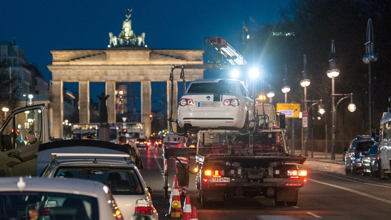 Ein Fahrzeug wird vor dem Brandenburger Tor in Berlin abgeschleppt: Noch immer ist die Zahl der durch Diplomatenfahrzeuge verursachten Verkehrsvergehen hoch. Rund 370.000 Euro Bußgeld mussten durch Immunität nicht gezahlt werden