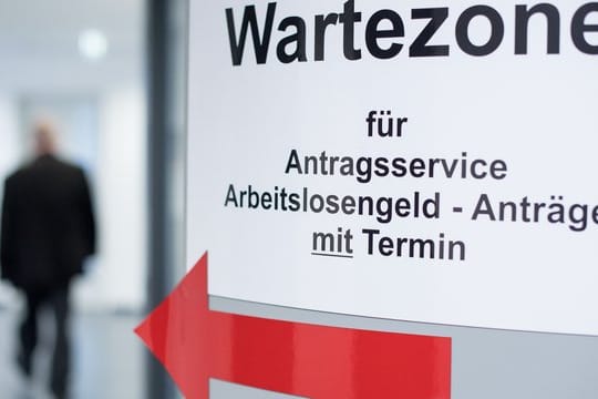 Ein Mann geht in den Wartebereich für den Antragsservice Arbeitslosengeld.