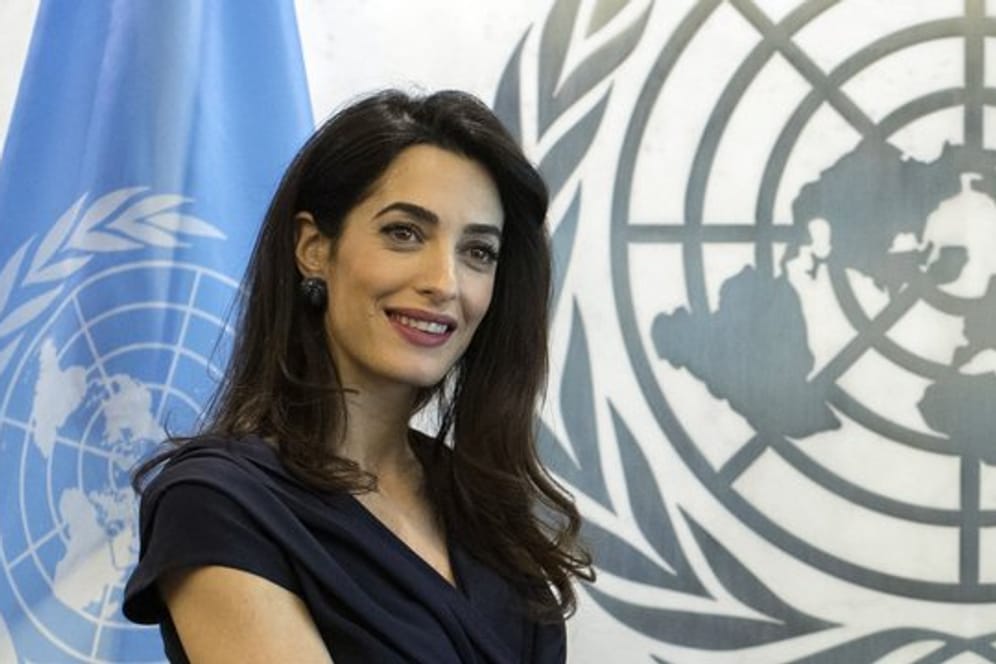 Rechtsanwältin Amal Clooney vor dem Logo und der Fahne der UN.