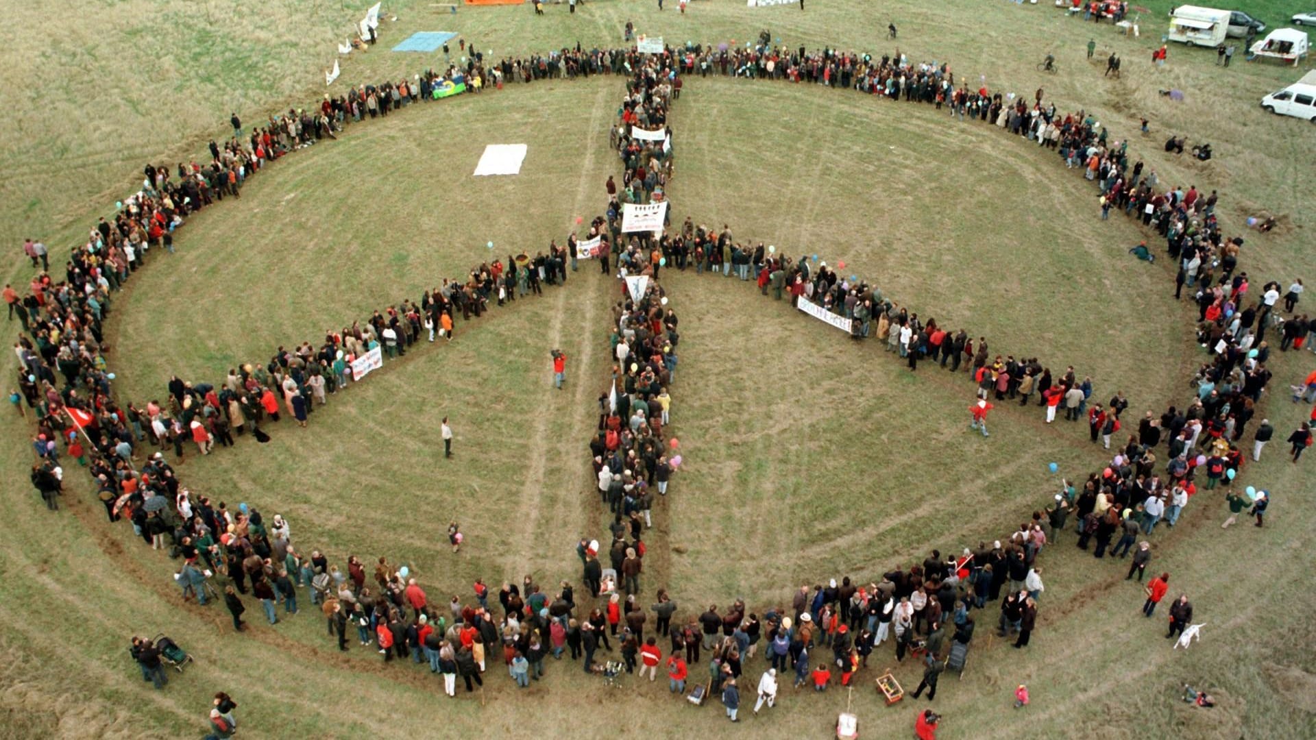 Peace-Zeichen (Archiv-Bild): In Brandenburg stellen sich Menschen zu einem Peace-Zeichen zusammen.