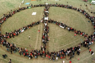 Peace-Zeichen (Archiv-Bild): In Brandenburg stellen sich Menschen zu einem Peace-Zeichen zusammen.