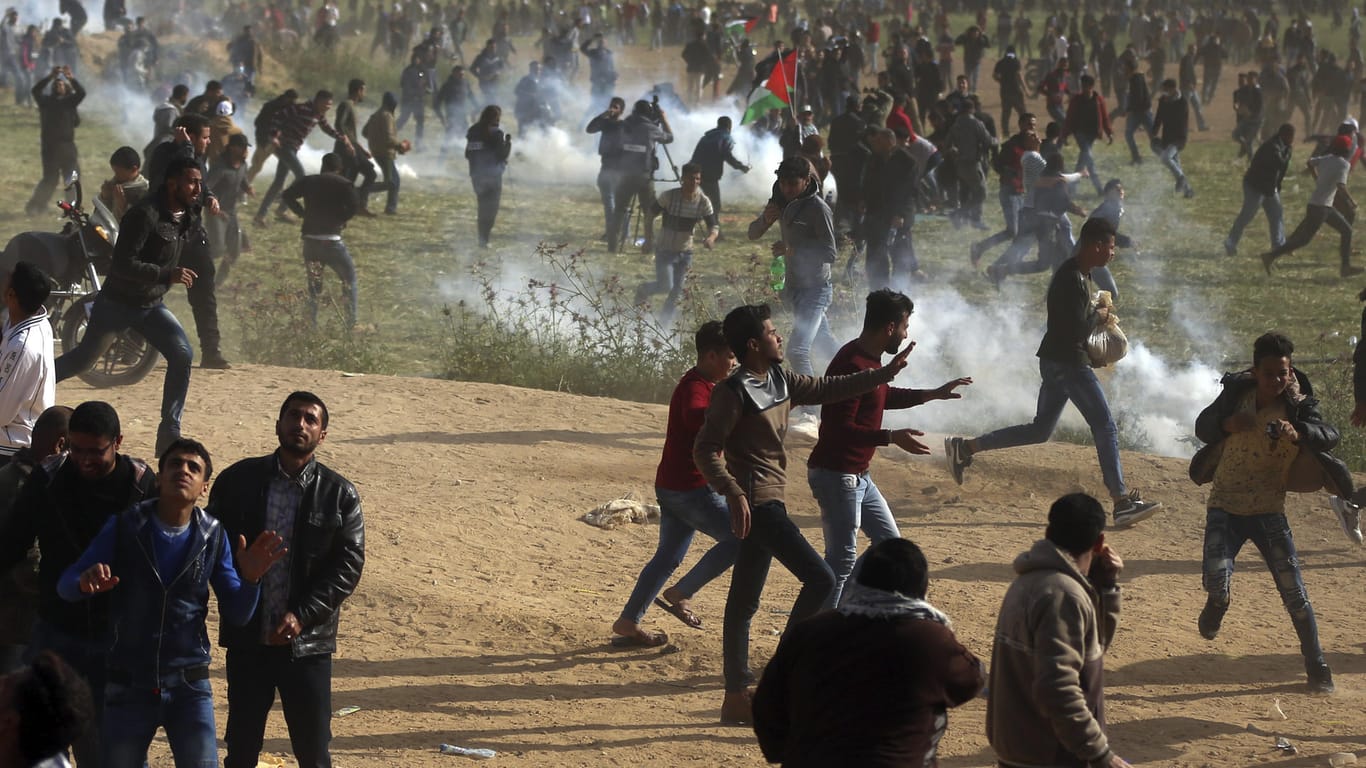 "Marsch der Rückkehr": Palästinensische Demonstranten gehen in Deckung, um sich vor Tränengas zu schützen.