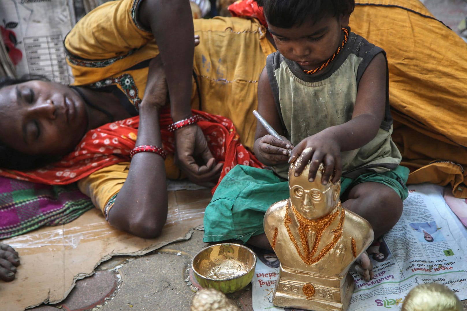 Ein Kind, das der indischen Kaste der Dalit angehört, malt eine Statue eines Freiheitskämpfers der Dalit an: In Indien ist ein 21-jähriger Mann dieser untersten Kaste offenbar wegen Besitz eines Pferdes getötet worden. (Archivbild)