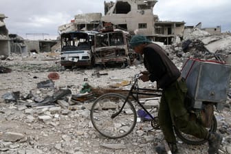 Ein Mann schiebt sein Fahrrad im zerstörten Duma: Die syrische Armee hat ihren Sieg über die Rebellen in der Region Ost-Ghuta erklärt.