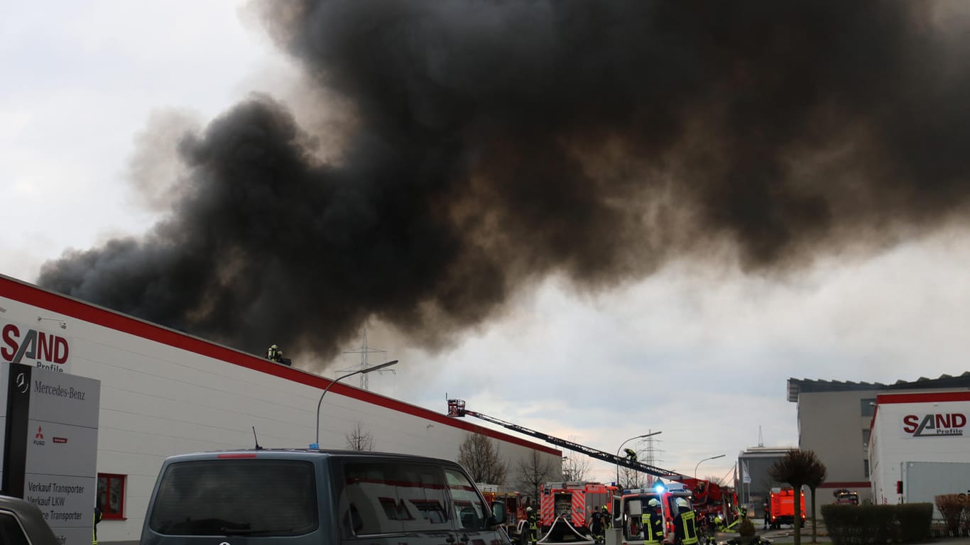 Feuer in Stockstadt: Dichter schwarzer Rauch steigt über einer Fabrik, in der Gummi und Kunststoffe verarbeitet werden, auf.
