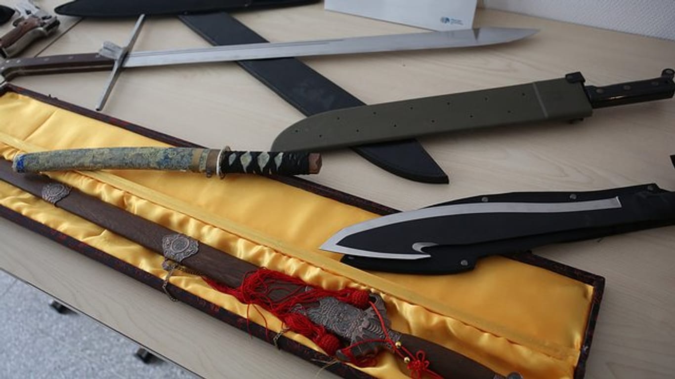 Beschlagnahmte Waffen, darunter verschiedene Messer, liegen im Polizeipräsidium Köln auf einem Tisch (Archiv).