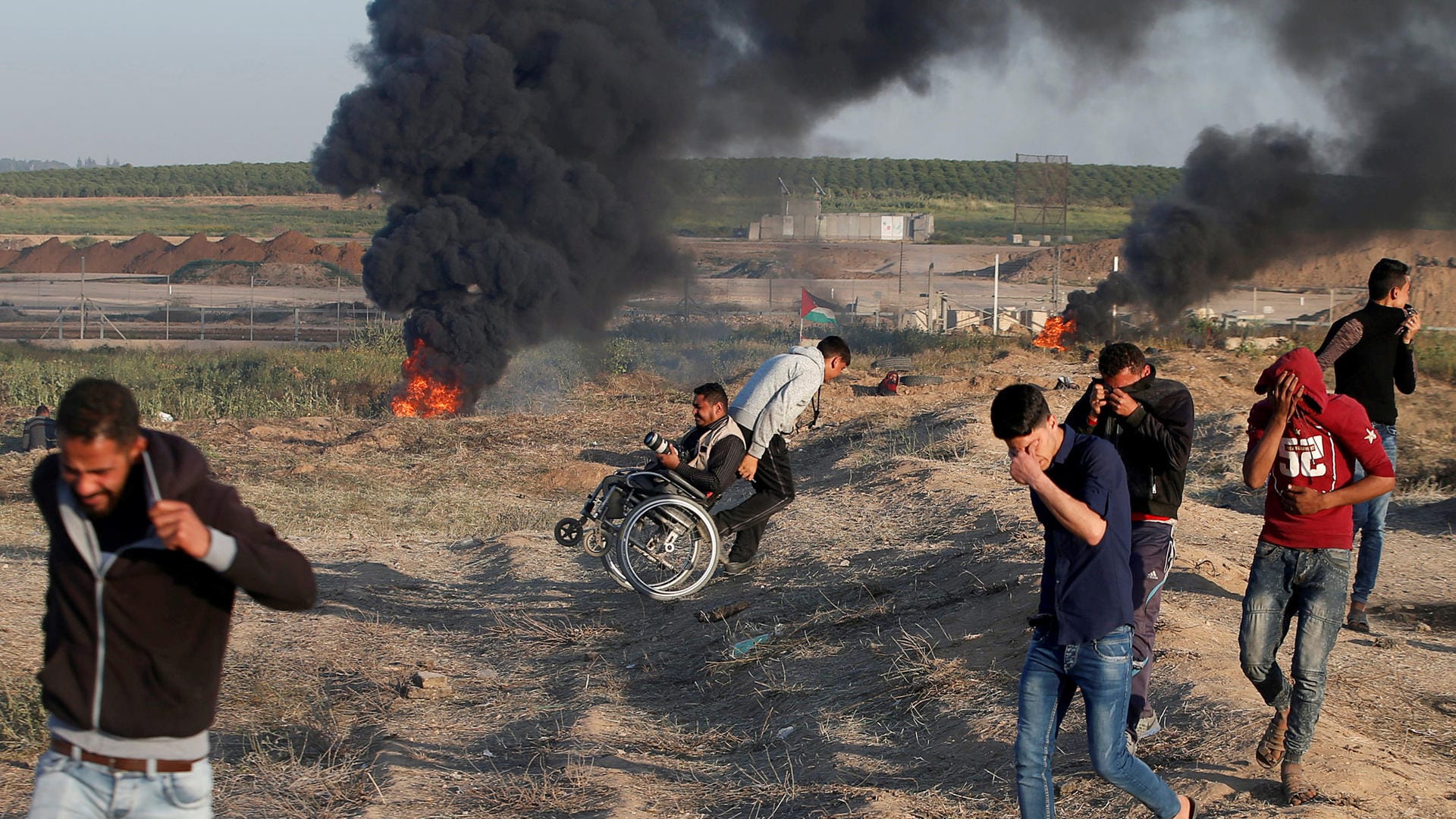 Palästinenser schützen sich vor den Angriffen und Tränengas bei den Massenprotesten am Gazastreifen: Die Zahl der verstorbenen Palästinenser beim "Marsch der Rückkehr" ist auf 18 gestiegen. Palästinenser schützen sich vor den Angriffen und Tränengas bei den Massenprotesten am Gazastreifen: Die Zahl der verstorbenen Palästinenser beim "Marsch der Rückkehr" ist auf 18 gestiegen.