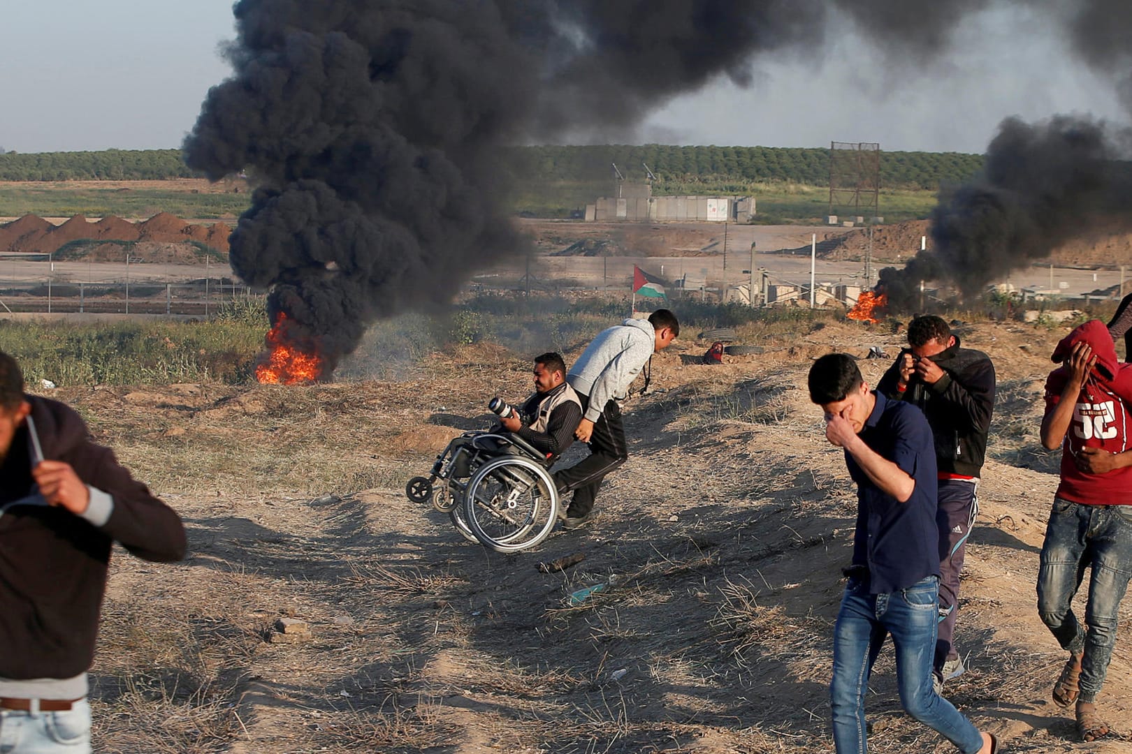 Palästinenser schützen sich vor den Angriffen und Tränengas bei den Massenprotesten am Gazastreifen: Die Zahl der verstorbenen Palästinenser beim "Marsch der Rückkehr" ist auf 18 gestiegen.