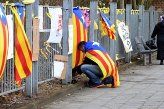 Ein Mann befestigt am Zaun vor der Justizvollzugsanstalt eine Estelada, die Fahne der katalanischen Nationalisten.